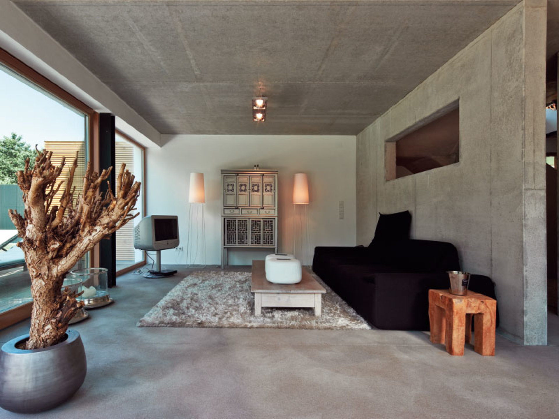 Haus Immel nutzt eine sehr natürliche Raumgestaltung durch Steinwände, Holztischen und große Baumstücke als Dekoration. (Foto: BAUMEISTER-HAUS)